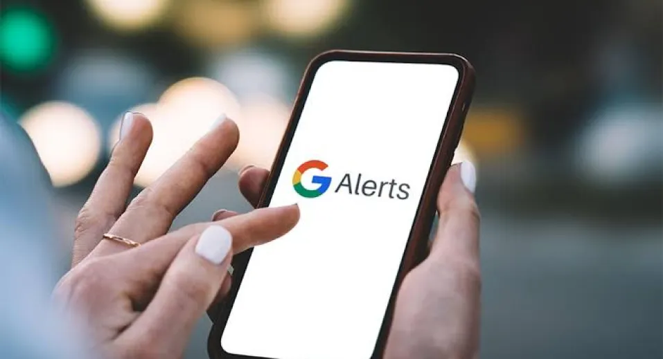 A hand holding a phone with Google's logo on it